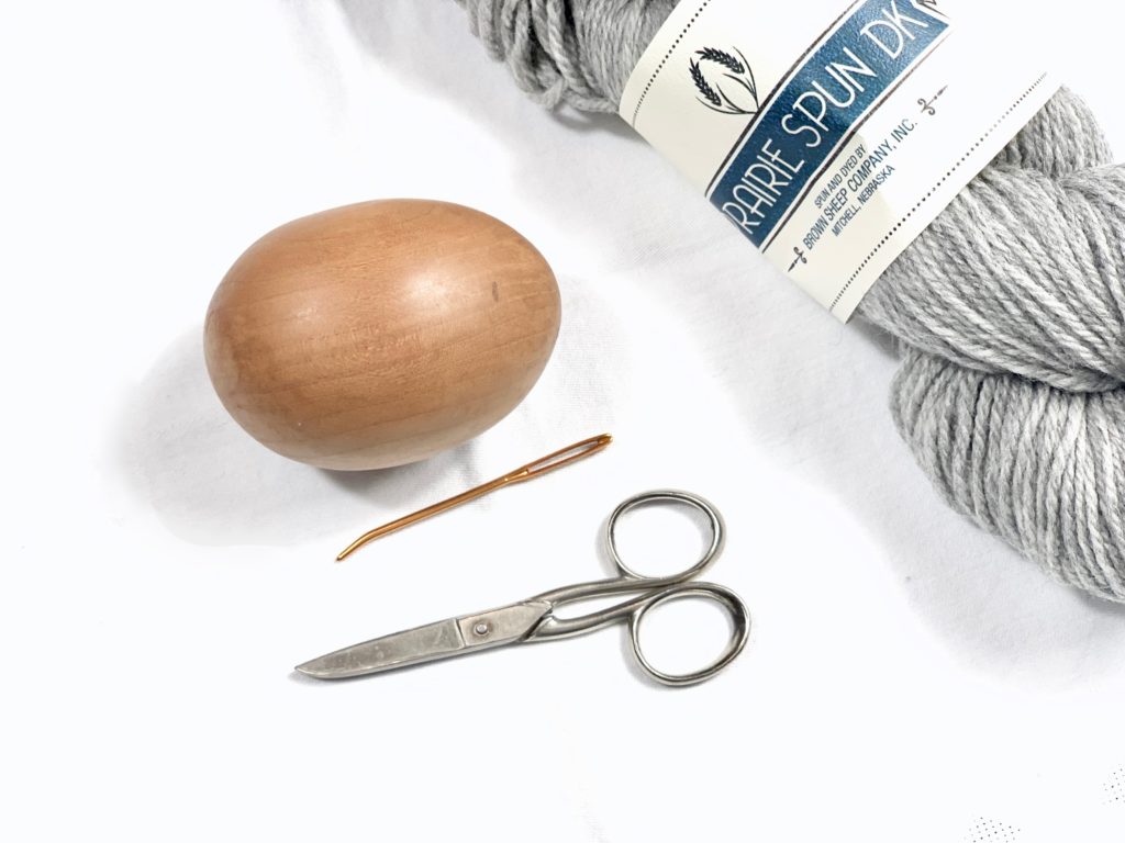 darning egg, darning needle, scissors, and grey yarn for darning