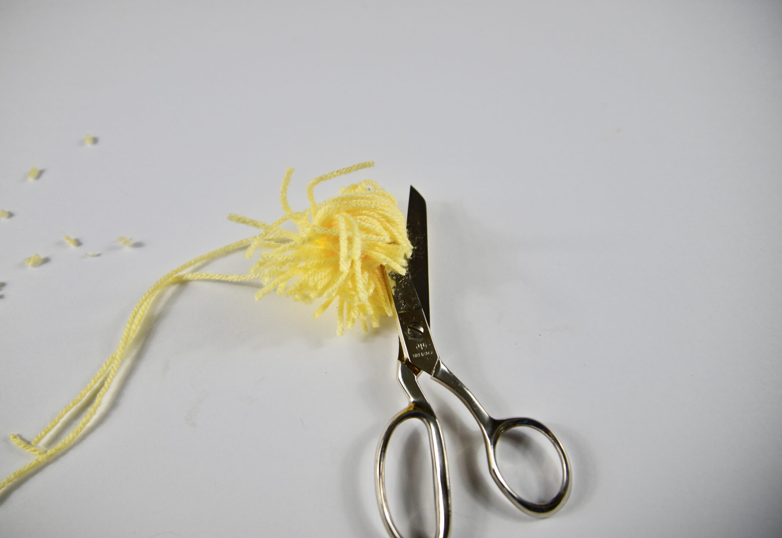 a yellow pom pom and scissors