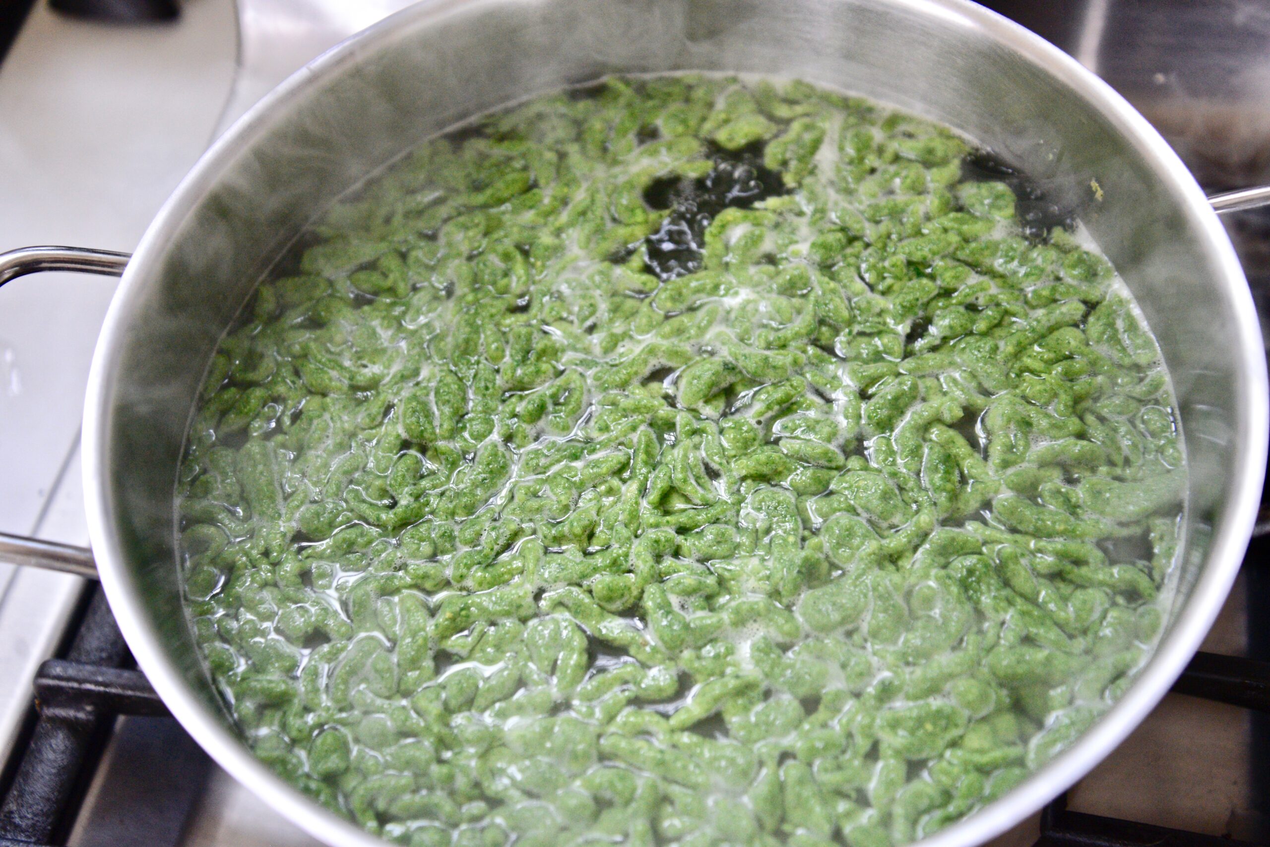 stinging nettle spaetzle in pot of boiling water