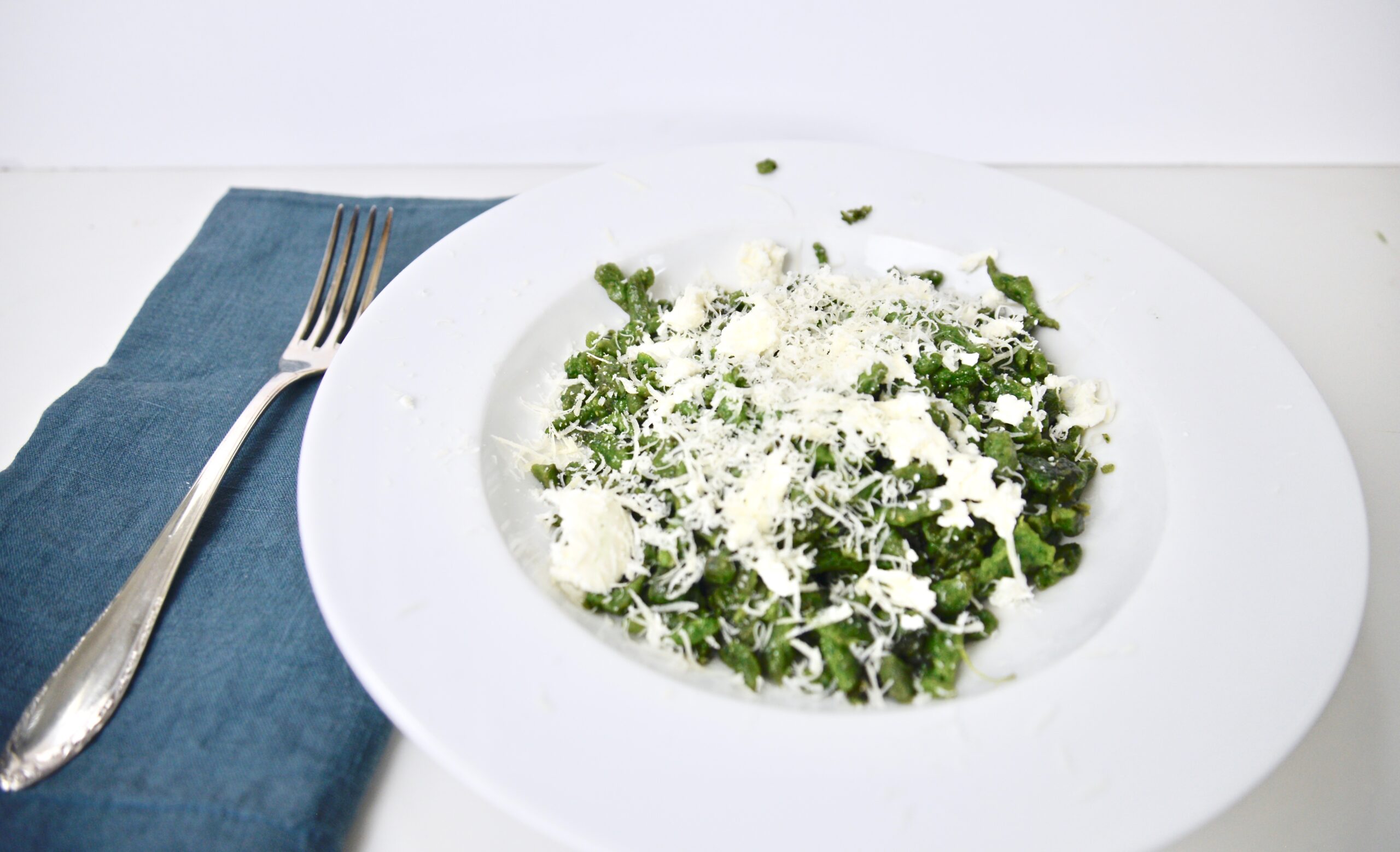 stinging nettle speatzle with cheese on plate with fork and napkin on the side