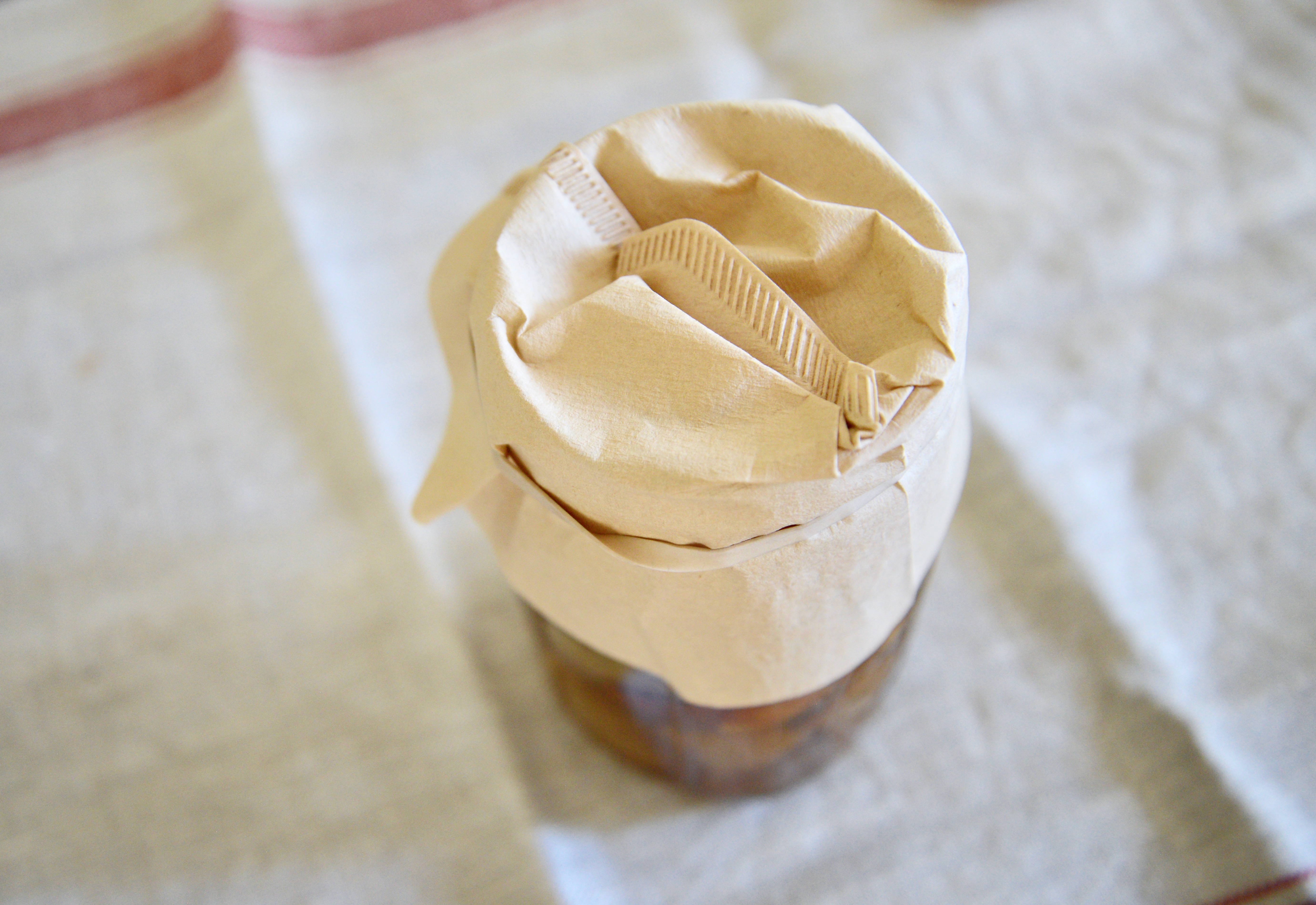 jar of fermenting apple cider vinegar covered with coffee filter