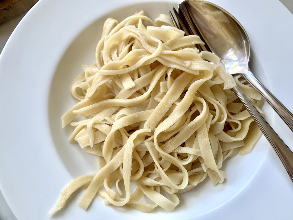 homemade sourdough fettucini on a plate with spoon and fork